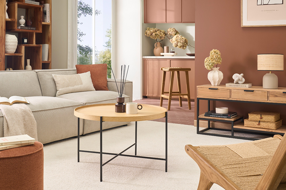 Runder Couchtisch aus hellem Holz und schwarzem Metall in einem modernen Wohnzimmer.