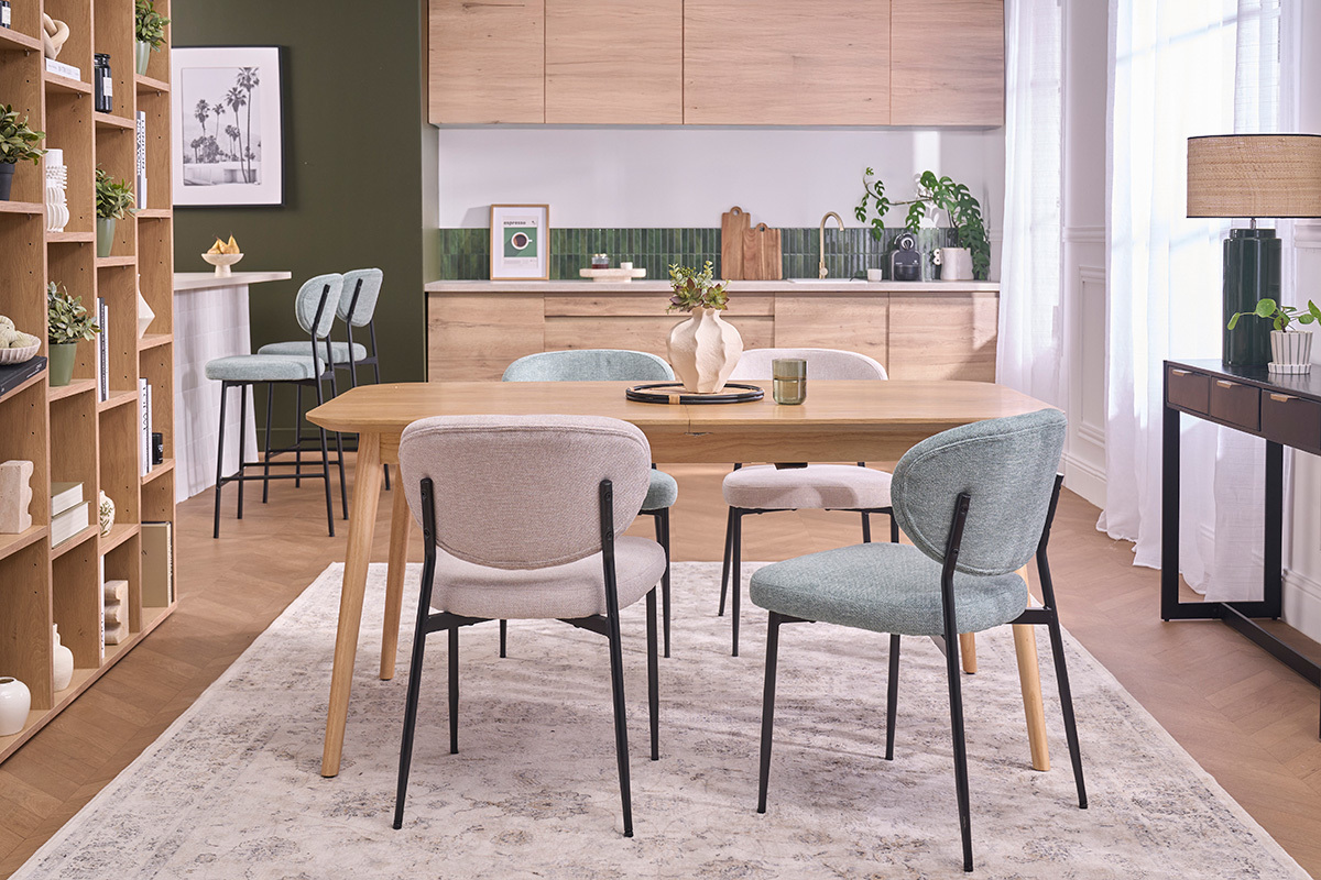 Celadongr�ne St�hle und schwarzes Metall um einen Holztisch in einem modernen Esszimmer.