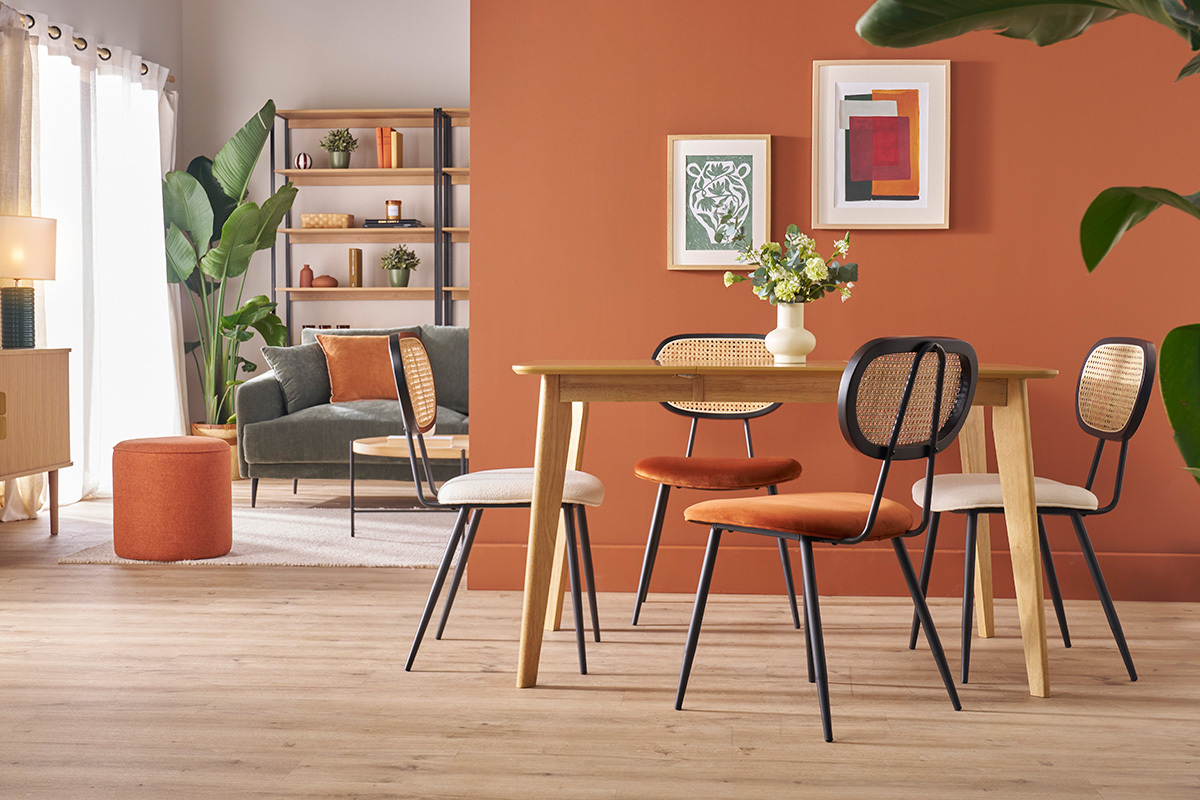 Designst�hle aus gebranntem Samt und Rattan um einen Tisch aus hellem Holz.