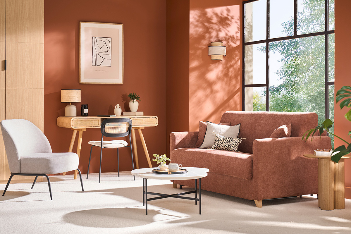 Schlafsofa aus verbranntem Erdefarbenem Stoff in einem Wohnzimmer mit Schreibtisch und Sessel.