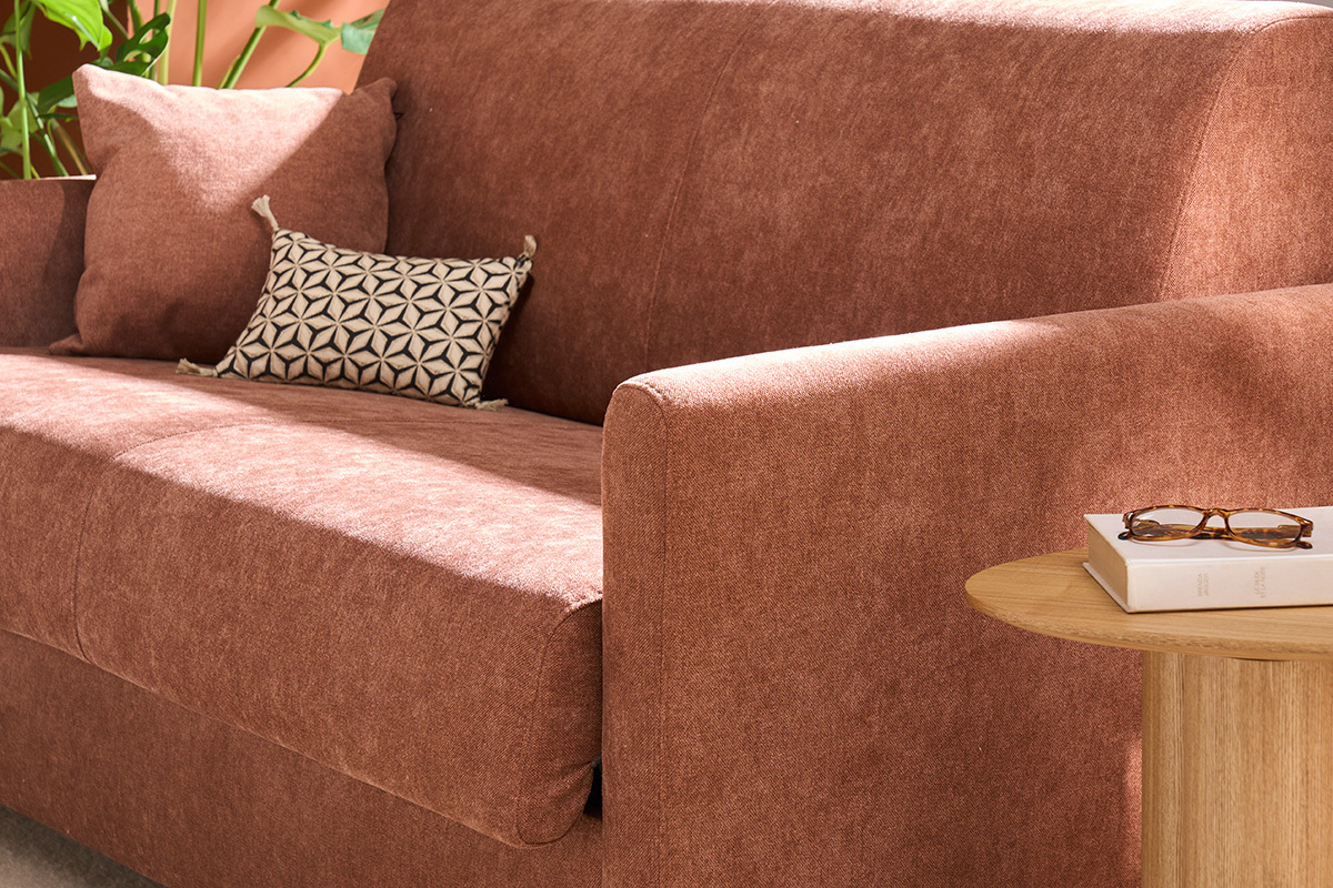 Samt-Schlafsofa in gebrannter Erde, rechte Armlehne und Kissen mit kleinem Holztisch.