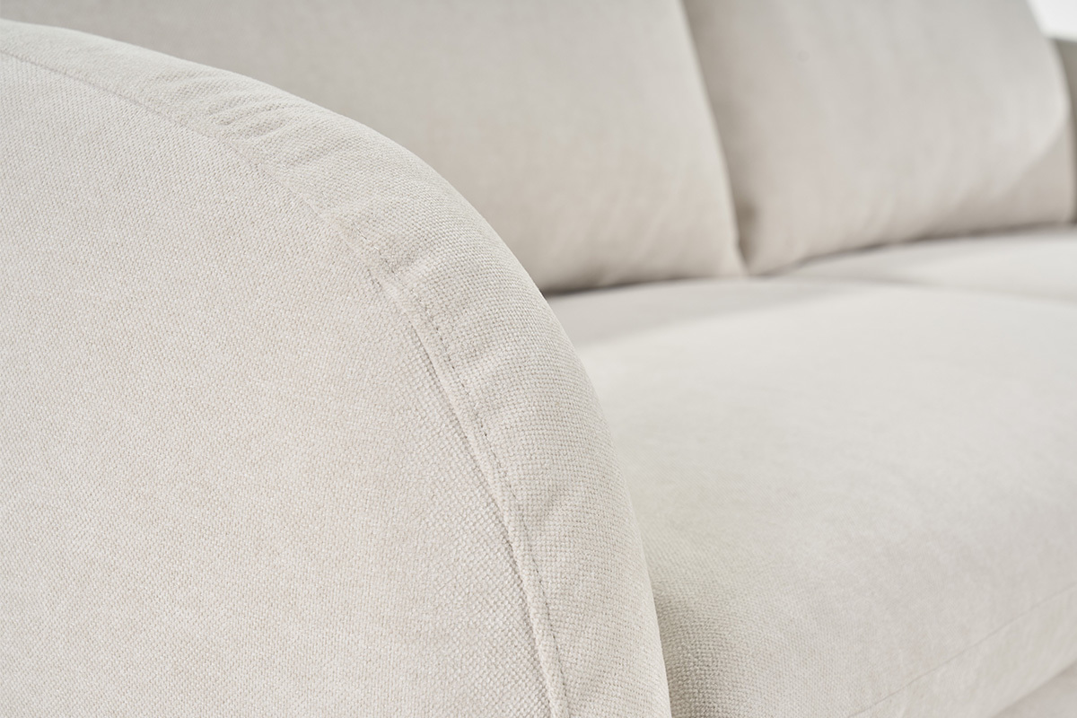 Nahaufnahme des beigefarbenen Stoffsofas mit Samteffekt, abgerundete Armlehne.