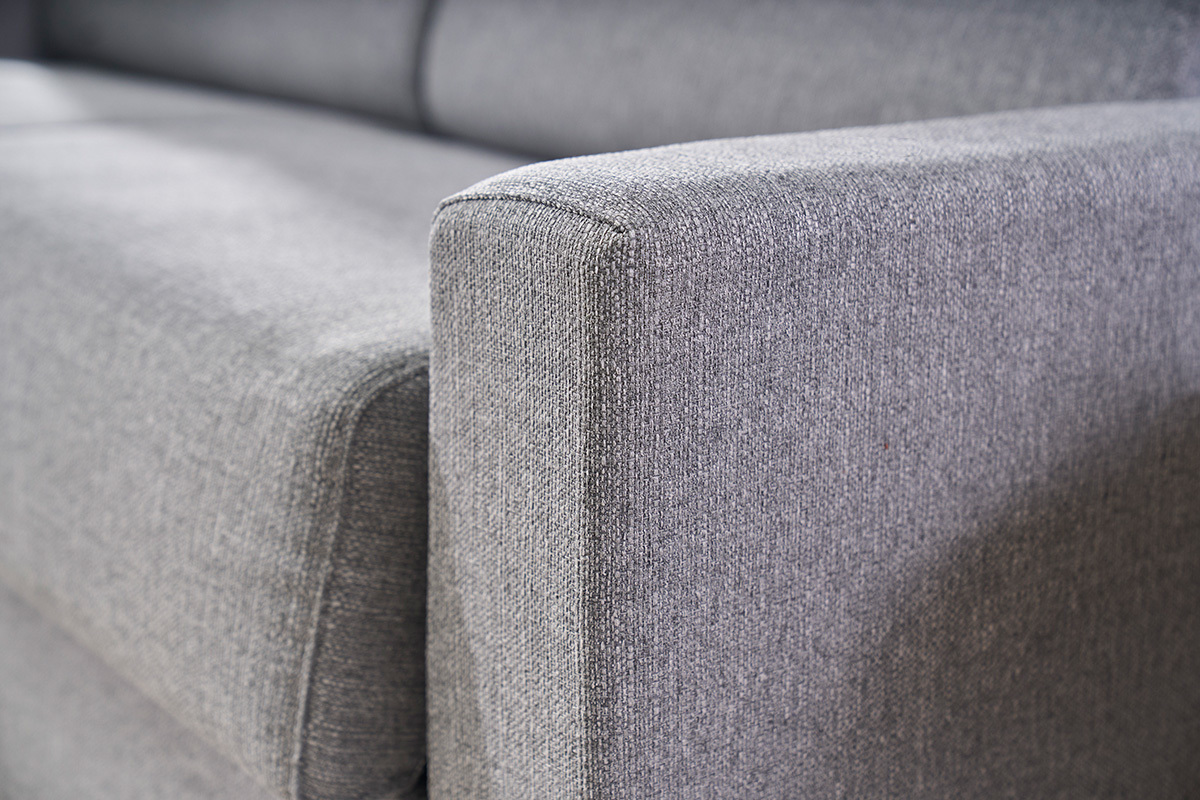 Detail der Armlehne eines 3-Sitzer-Schlafsofas aus hellgrauem Stoff