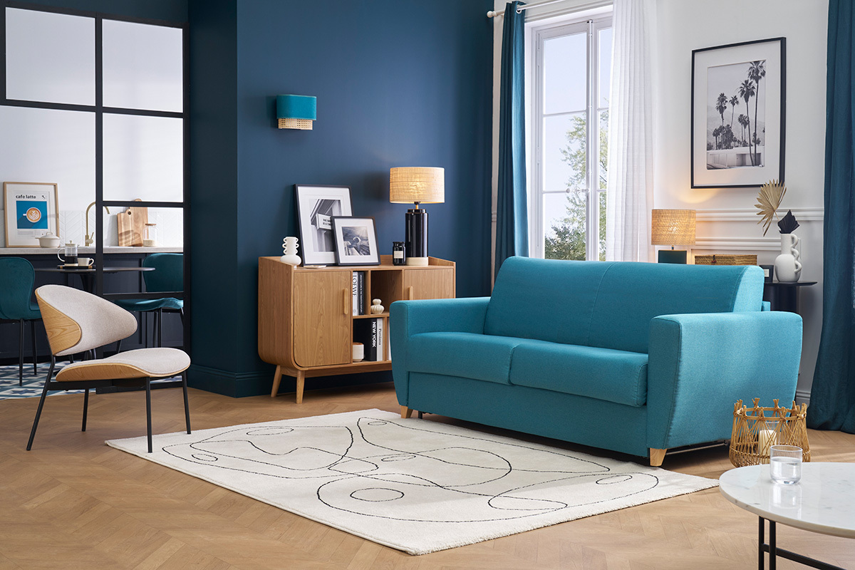 Dreisitzer-Schlafsofa in Petrolblau, Frontansicht, in einem modernen Wohnzimmer.