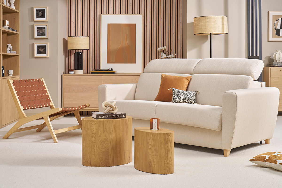 Beiges Schlafsofa GOYA mit verstellbaren Kopfst�tzen, Frontansicht, in einem Wohnzimmer mit hellen Holzm�beln.