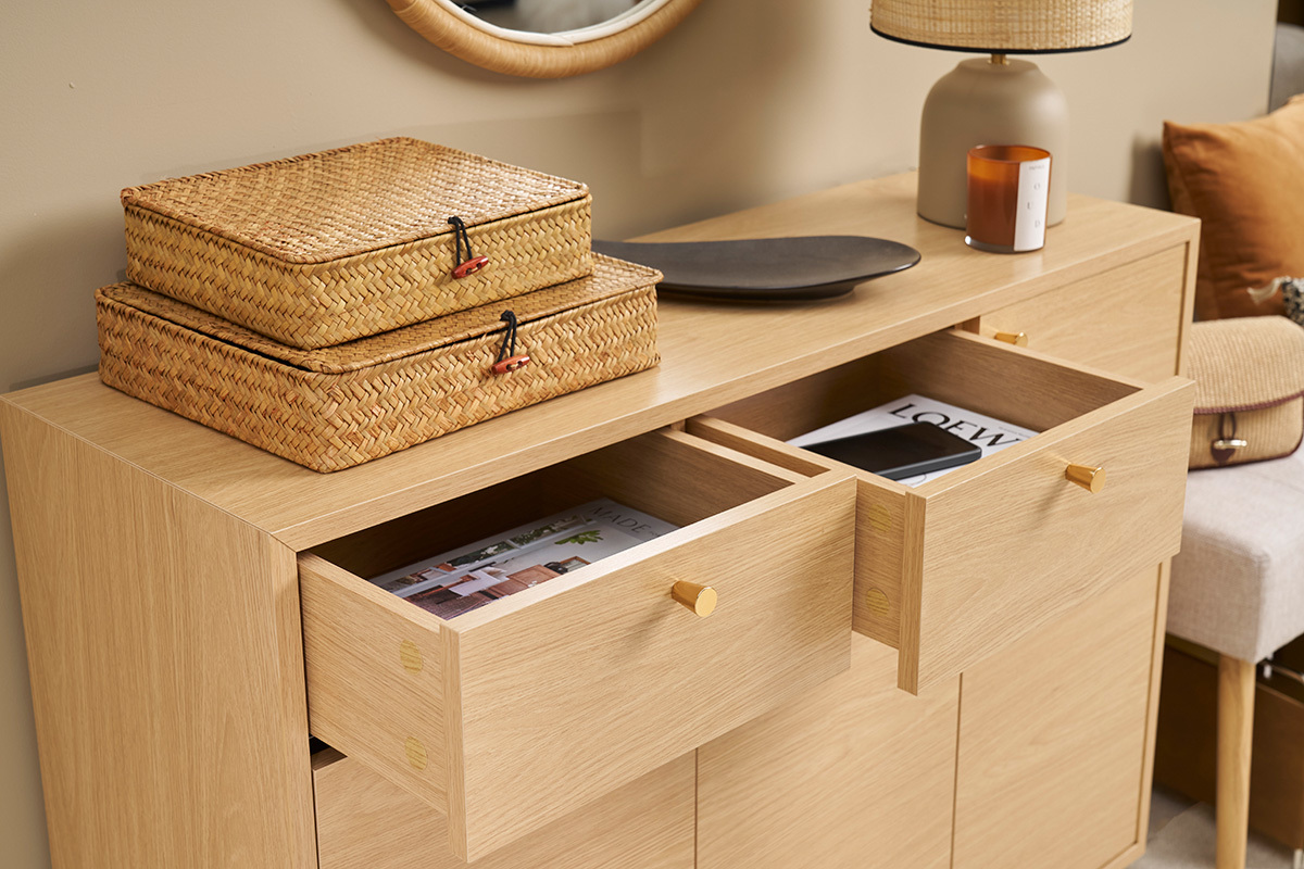 Helles Holzmbel fr den Eingangsbereich mit offenen Schubladen und darauf platzierten Gegenstnden, Ansicht von 3/4.