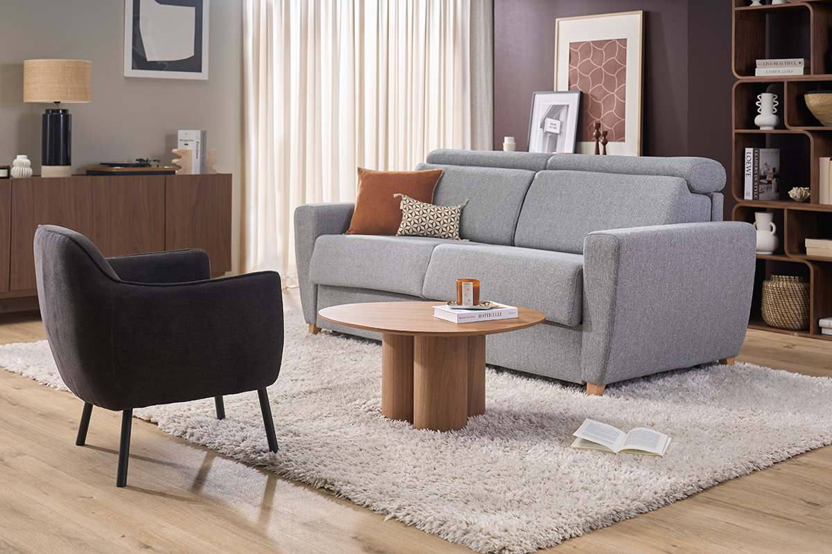 Designsessel aus Stoff in dunkelgrauer Samtoptik, Seitenansicht, mit modernen M�beln drumherum.