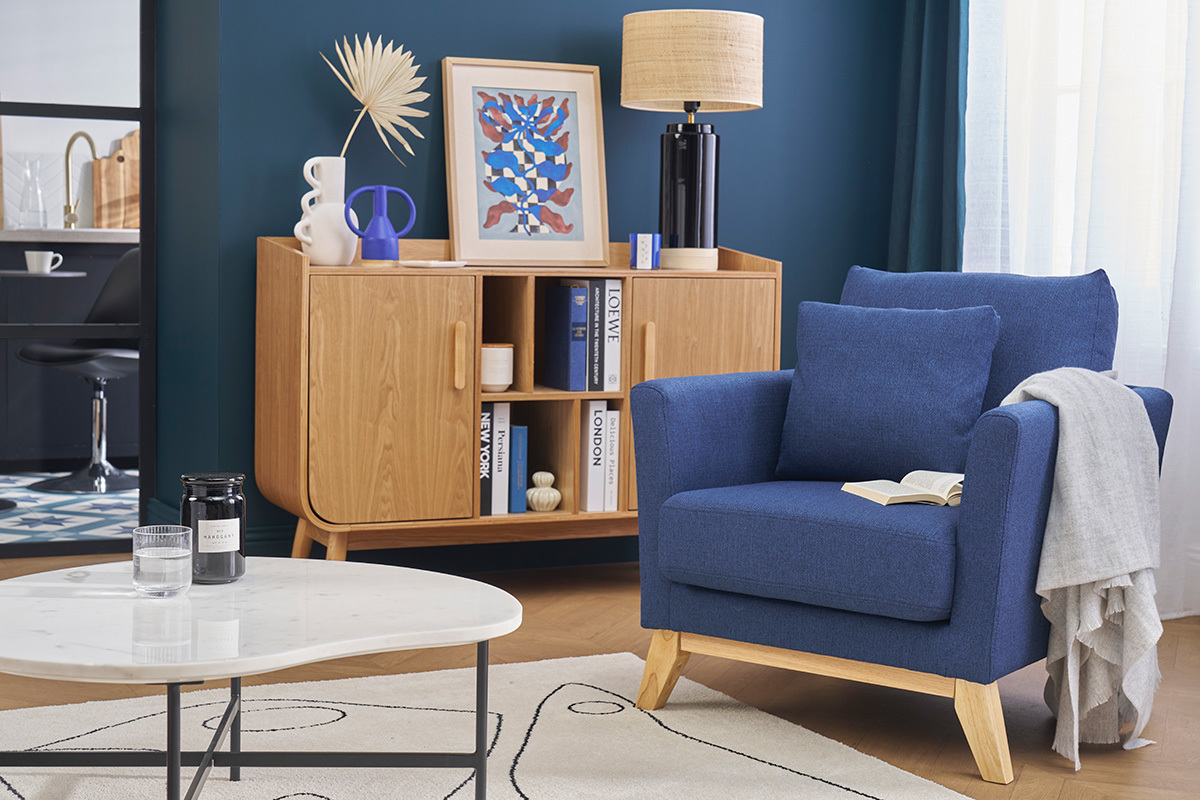 Dunkelblauer skandinavischer Sessel und helles Holz in einem modernen Wohnzimmer.