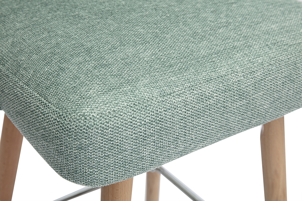 Gr�ner, texturierter Celadon-Stoffbezug des Hockers auf Holzf��en.