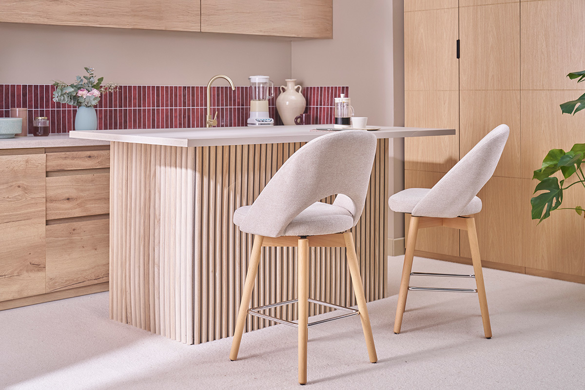 Zwei Barhocker aus beigem Stoff und Holzbeinen in einer K�che.