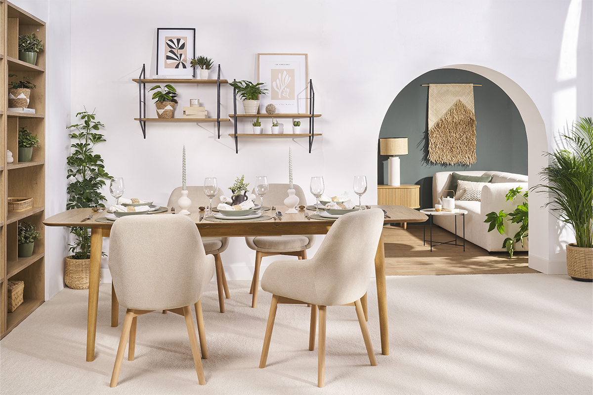 Esszimmer mit skandinavischen Sesseln in Beige aus Stoff und hellen Holzf��en um einen Tisch.