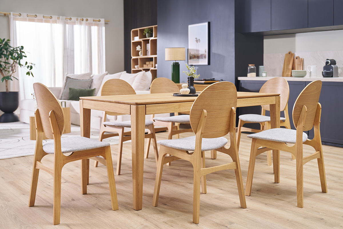 Skandinavische ELTON-St�hle aus hellem Holz und hellgrauem Stoff um einen Esstisch, 3/4-Ansicht