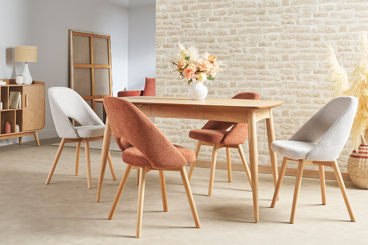 Skandinavische St�hle aus Stoff und hellem Holz, um einen Holztisch herum pr�sentiert.