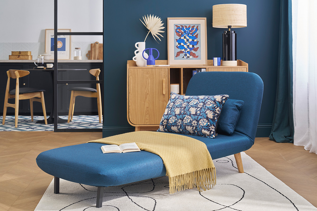 Dunkelblauer Schlafsessel AMIKO vor skandinavischer Deko-Kulisse, Seitenansicht.