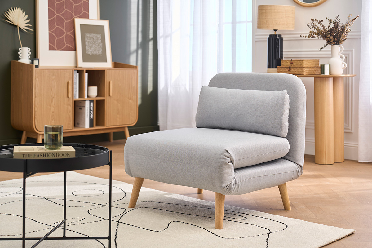 Wandelbarer Sessel aus hellem Stoff und hellem Holz, 3/4-Ansicht in einem eleganten Wohnzimmer.