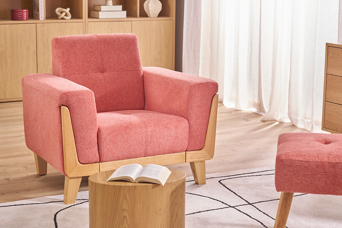 Skandinavischer Sessel aus Terrakotta-Stoff und hellem Holz, Frontansicht, mit Couchtisch davor.