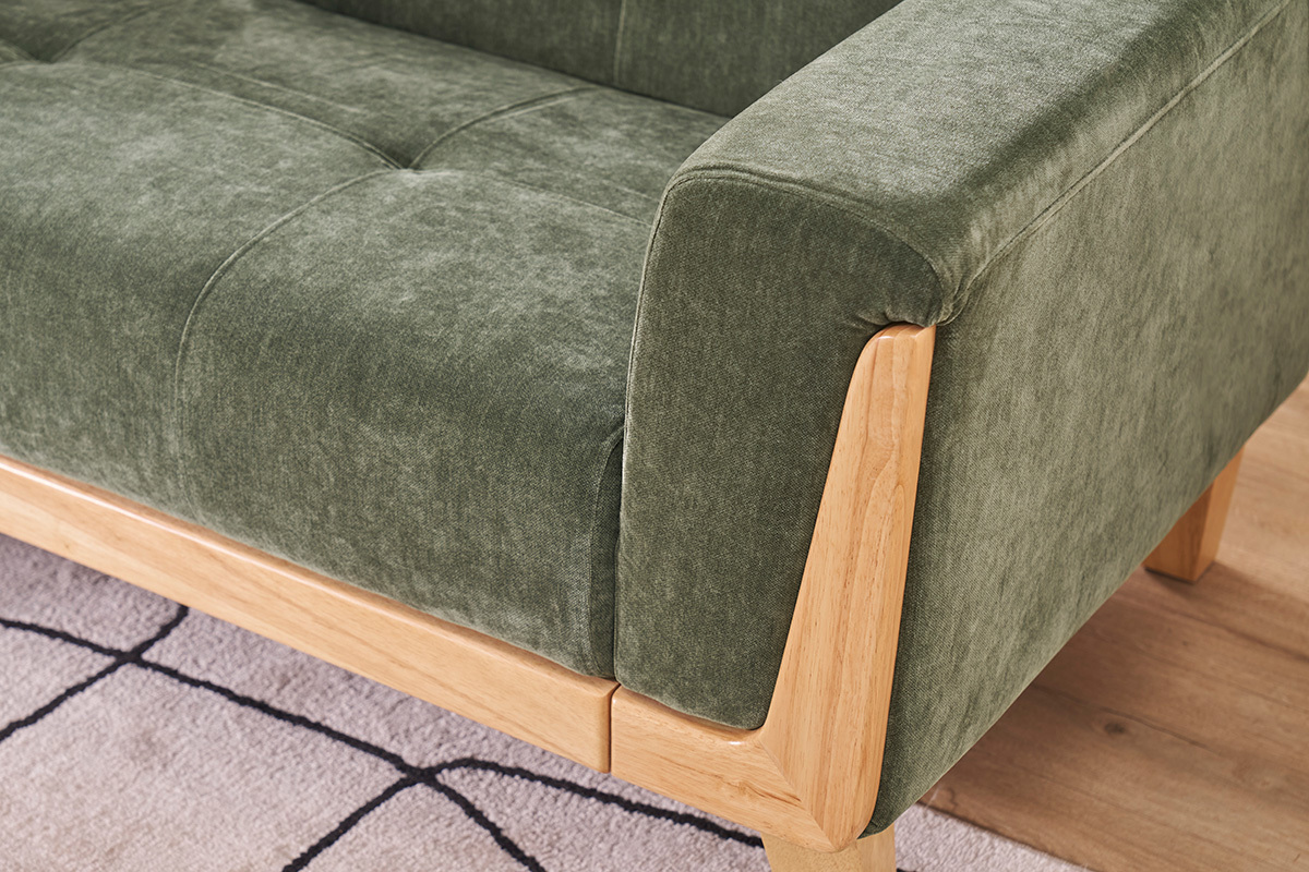Detail eines khakigr�nen skandinavischen Sofas aus Samteffekt-Stoff mit Armlehne aus hellem Holz.