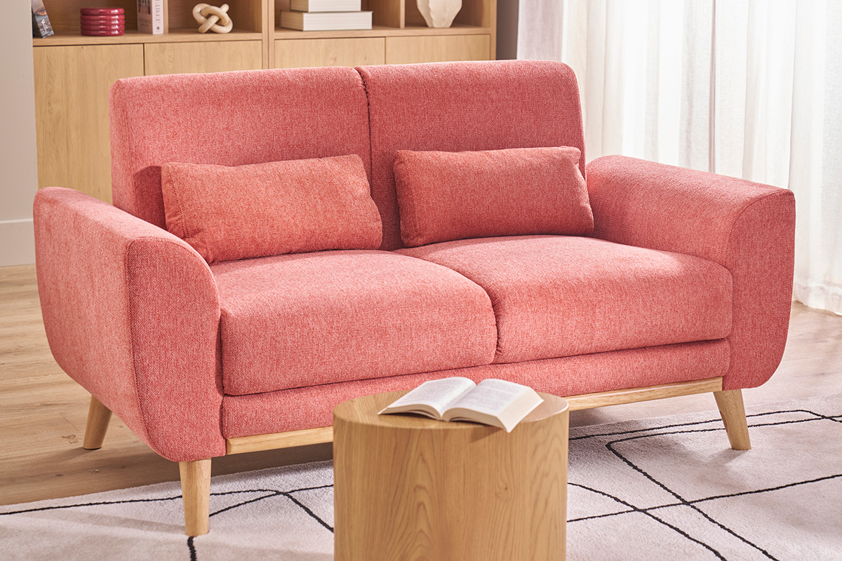 Skandinavisches Terracotta-Sofa f�r 2 Personen mit Kissen, helle Holzbeine, Couchtisch davor.