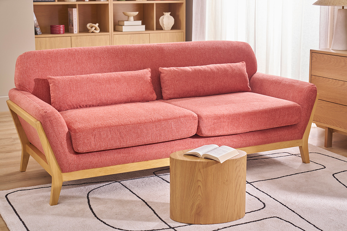 YOKO 3-Sitzer Sofa Terrakotta in Samtoptik, helle Holzstruktur, Frontansicht in einem Wohnzimmer.