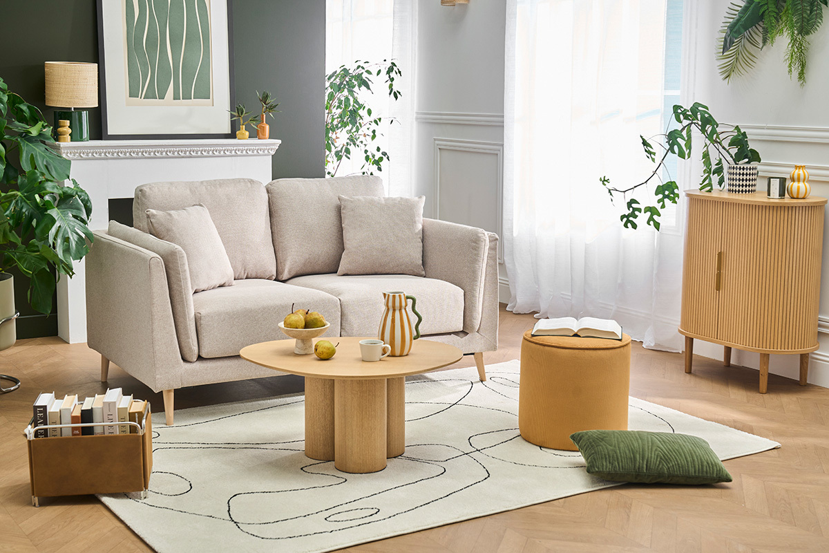 Skandinavisches 2-Sitzer-Sofa in Beige mit Kissen, Tisch und Deko-Zubeh�r in einem hellen Wohnzimmer.