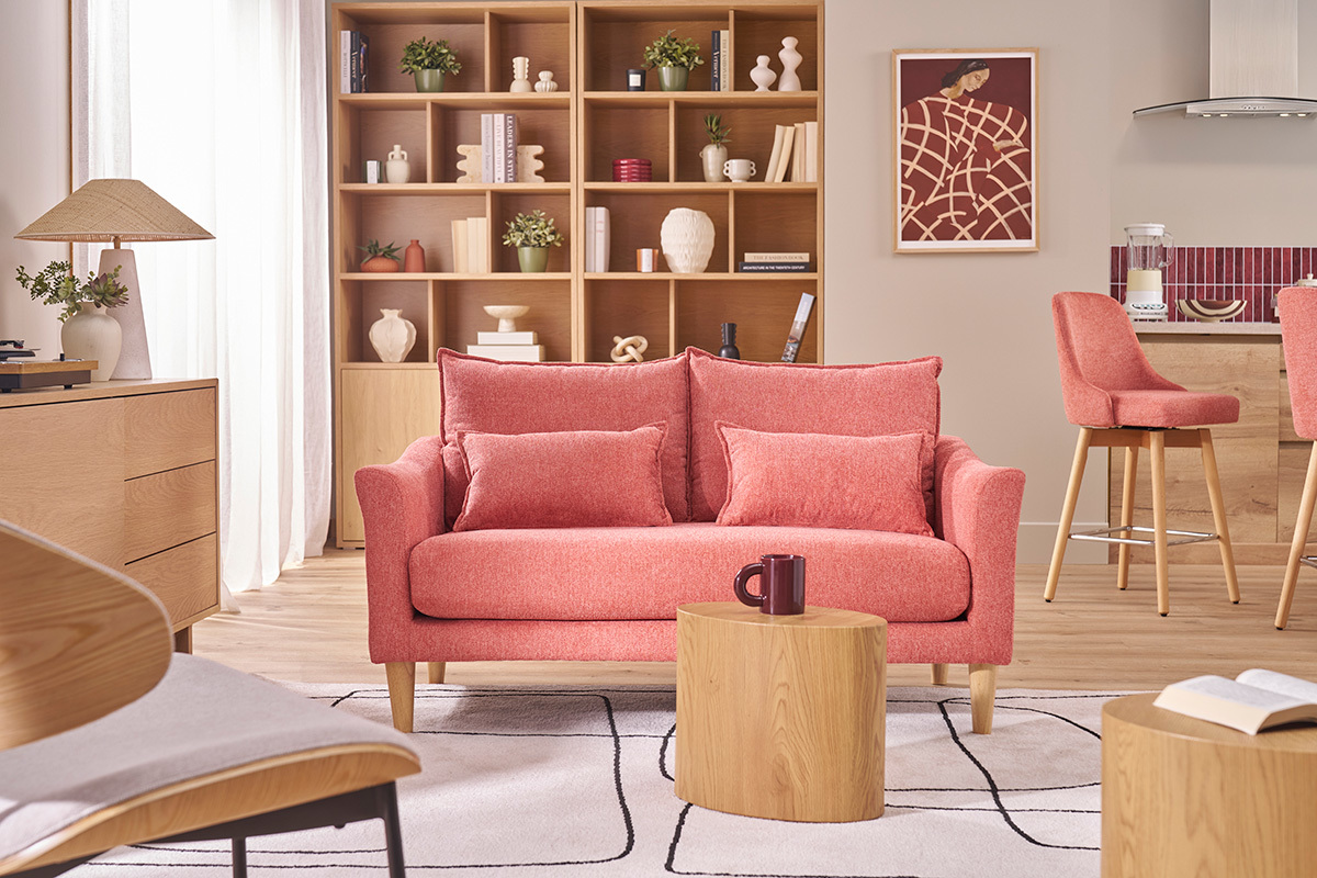 Zweiersofa aus Terrakotta-Stoff und hellem Holz, Frontansicht, in einem Wohnzimmer.