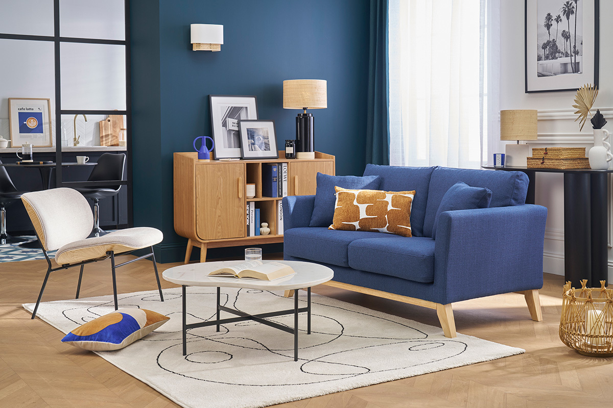 Wohnzimmer mit dunkelblauem skandinavischem Stoffsofa und Holzbeinen, Couchtisch und hellem Holzm�bel.