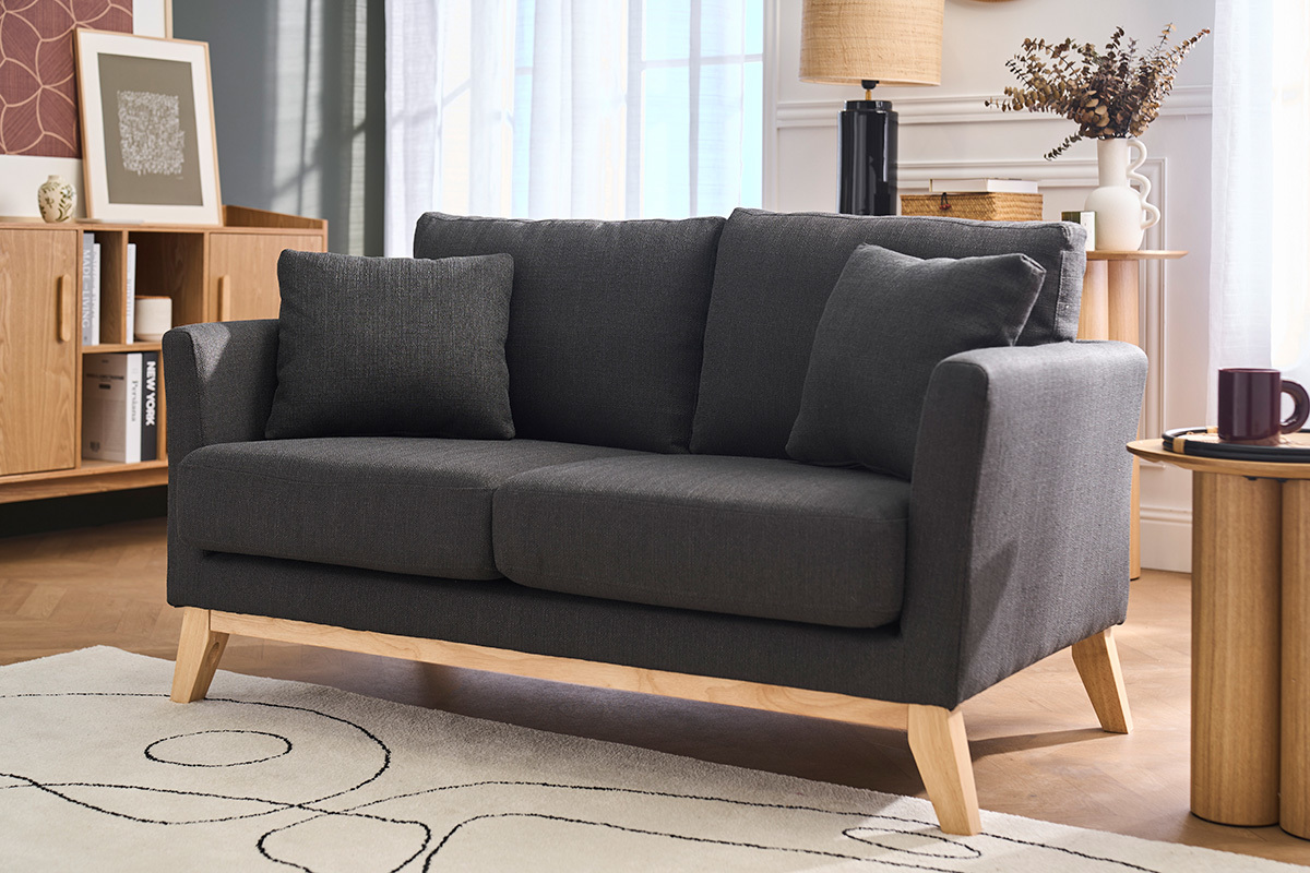 Dunkelgraues Stoffsofa mit 2 Sitzpl�tzen und hellem Holz, 3/4 Ansicht in einem Wohnzimmer.