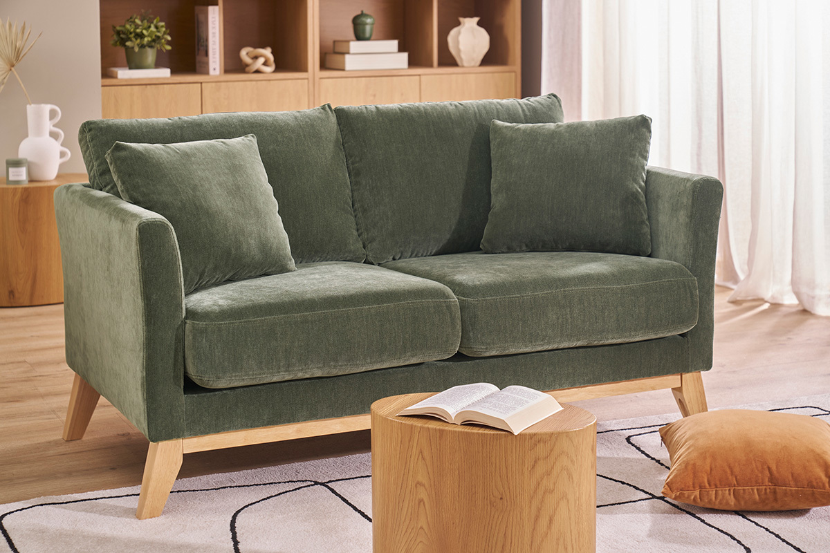 Zweiersofa in Khakigr�n aus Samtstoff und hellem Holz, Frontansicht, mit Kissen.