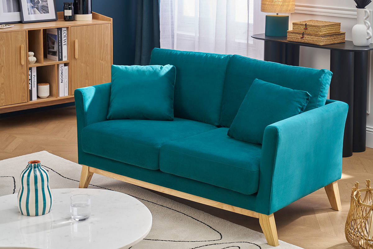 Skandinavisches 2-Sitzer-Sofa aus petrolblauem Samt und hellem Holz in einem modernen Wohnzimmer.