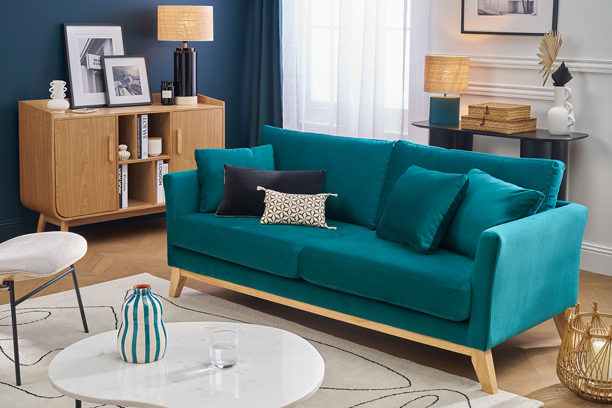 Skandinavisches Sofa in Petrolblau mit Holzbeinen, Frontansicht, in einem modernen Wohnzimmer.