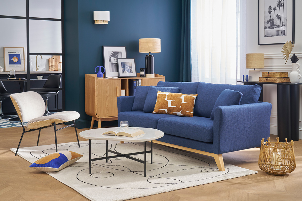 Blaues skandinavisches Sofa f�r 3 Personen mit Kissen, Frontansicht in einem modernen Wohnzimmer.