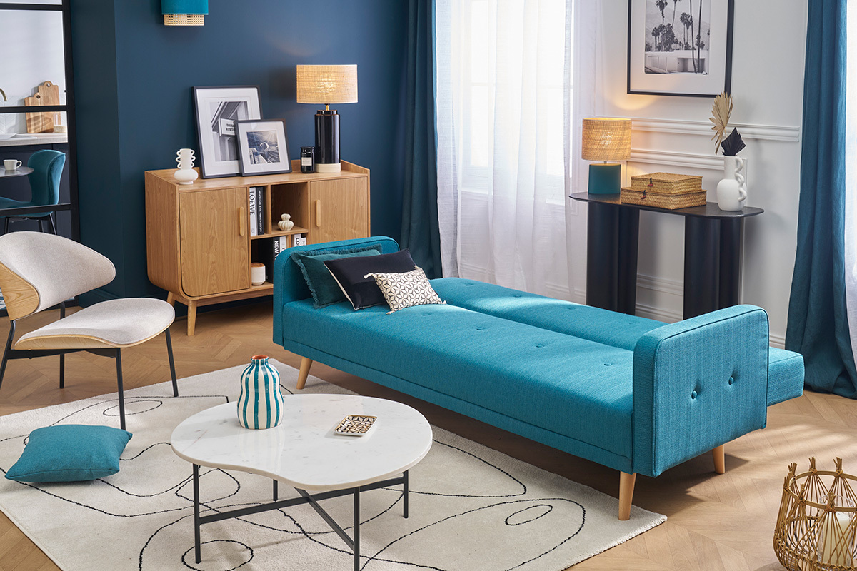 Skandinavisches Schlafsofa in Blau und hellem Holz im Bettmodus in einem modernen Wohnzimmer.