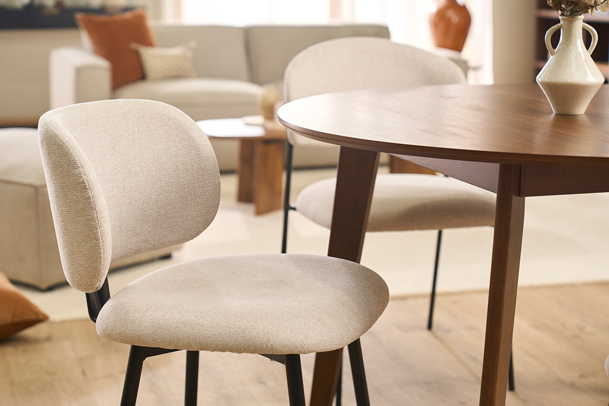 Beige St�hle aus Stoff mit schwarzem Metallgestell um einen Holztisch, teilweise Ansicht.