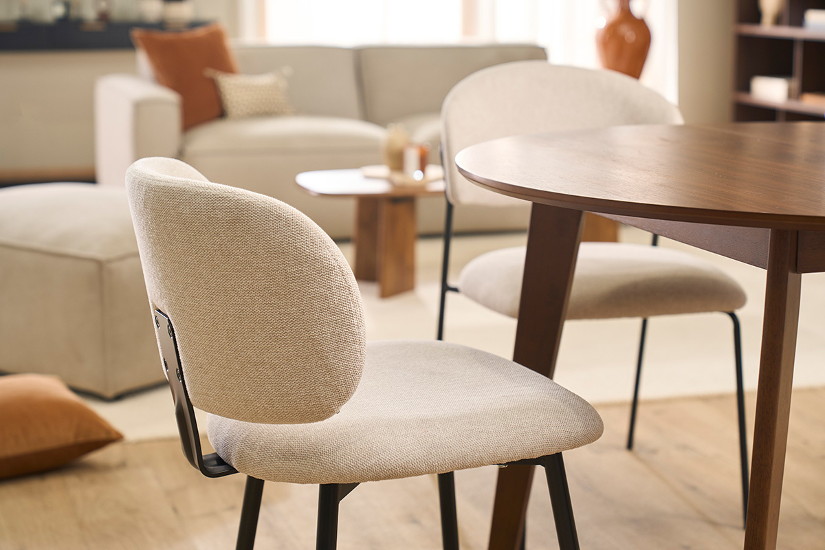 ATRIUM St�hle aus beigem Stoff und schwarzem Metall um einen Holztisch.