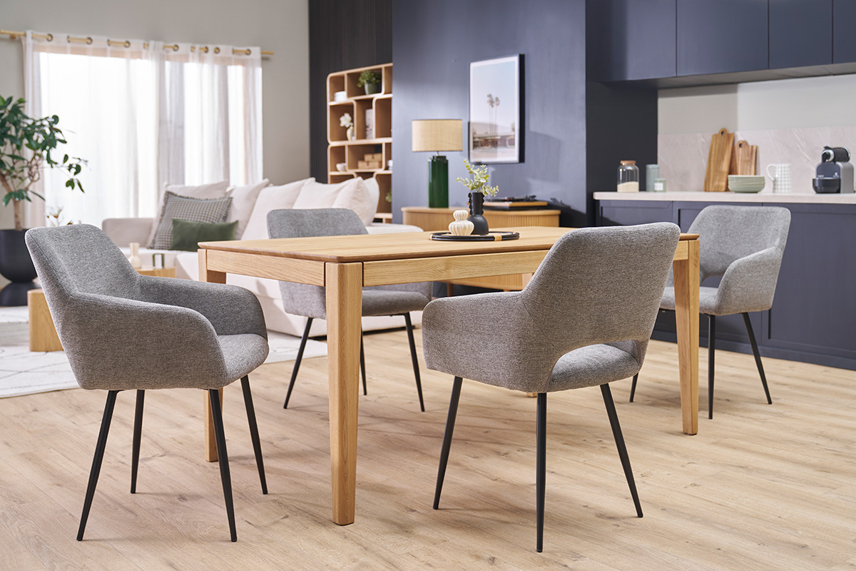 Vier LAURETTE St�hle aus grauem Samtstoff und schwarzem Metall um einen Holztisch in einem Wohnzimmer.