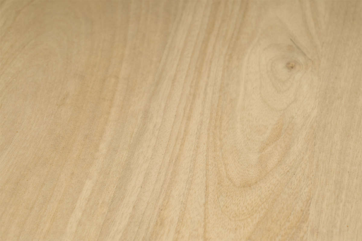 Nahaufnahme der massiven Mangoholzplatte eines Couchtisches.