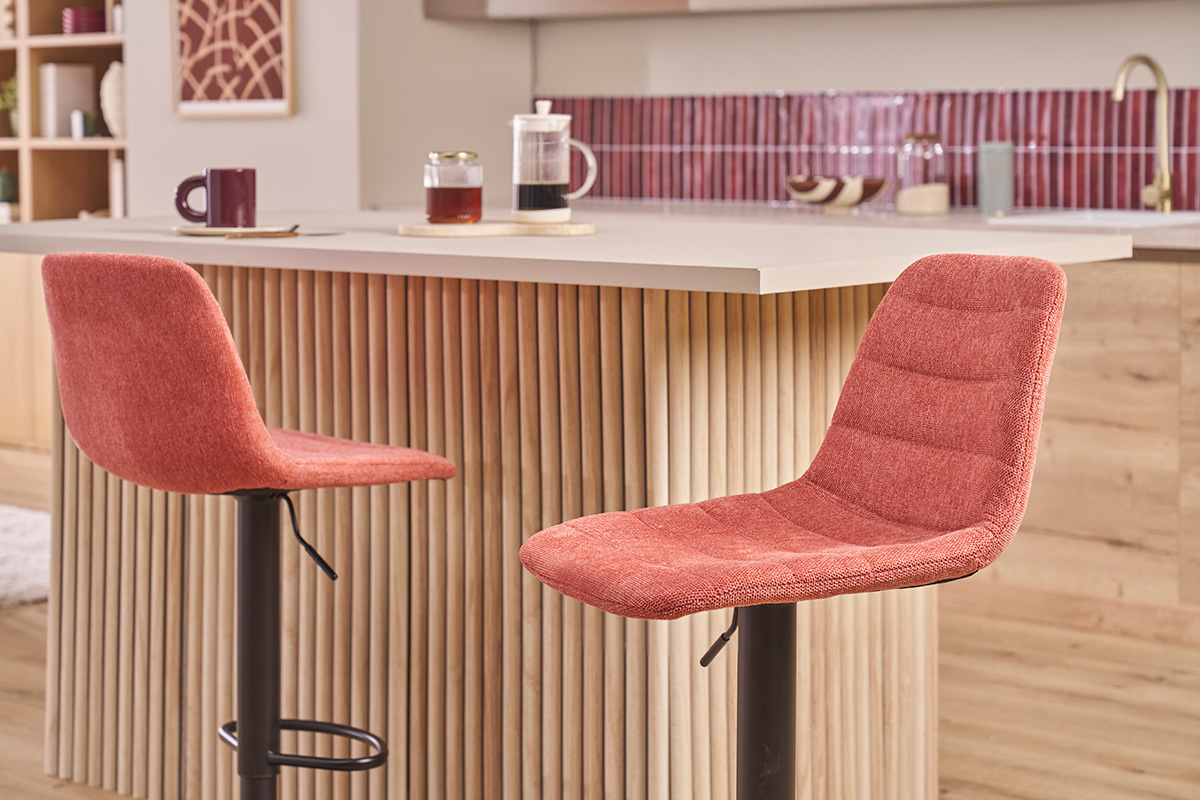 Zwei Terrakotta-Stoff-Barhocker mit schwarzen Metallf��en vor einer K�cheninsel.