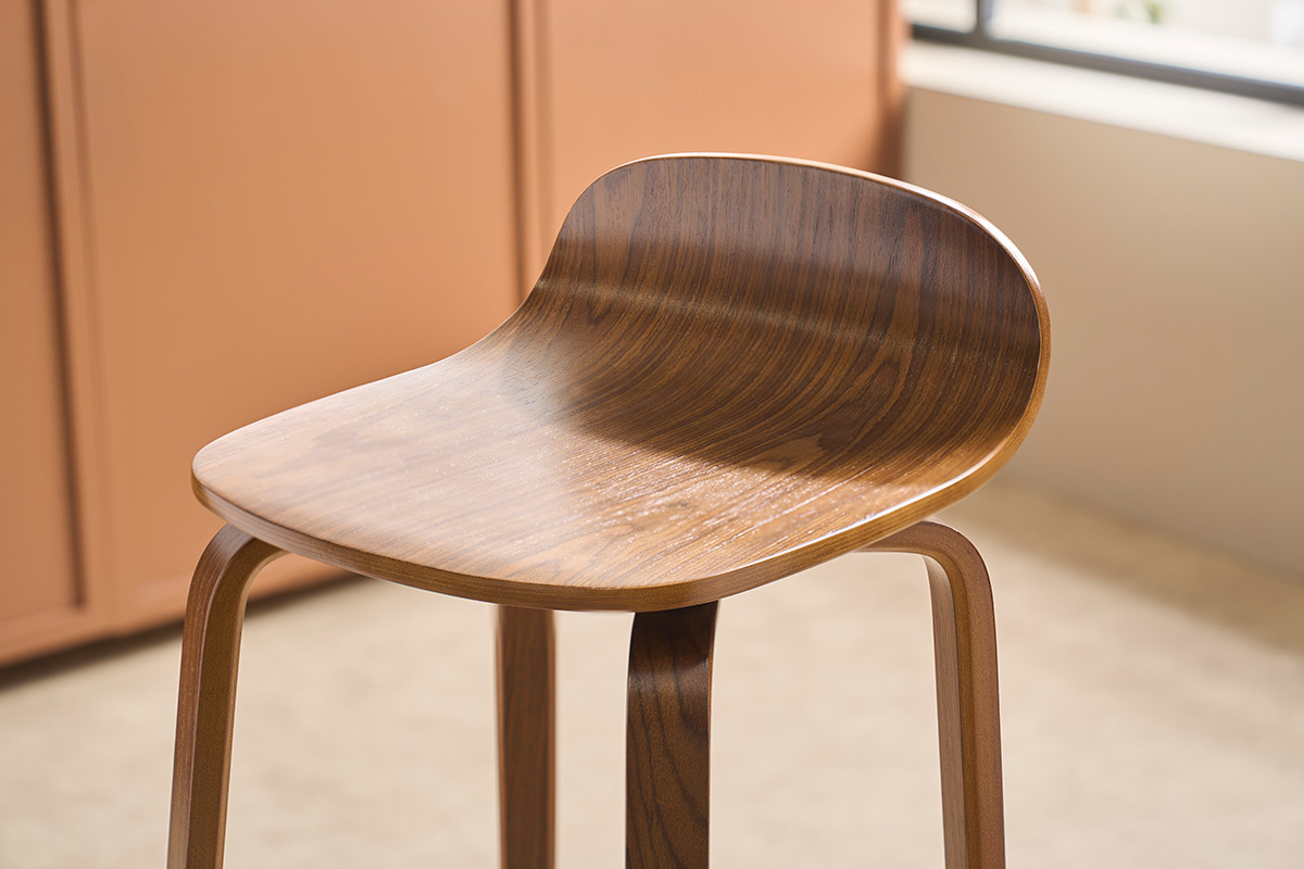 Nahaufnahme eines Vintage-Barhockers aus Nussbaum, mit breiter Sitzfl�che und gebogener R�ckenlehne.