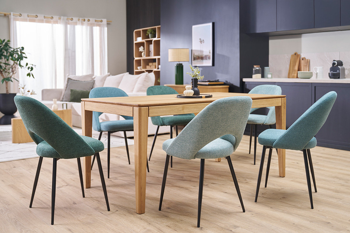 Vintage gr�ne St�hle um einen Holztisch mit schwarzen Metallbeinen, Gesamtansicht.