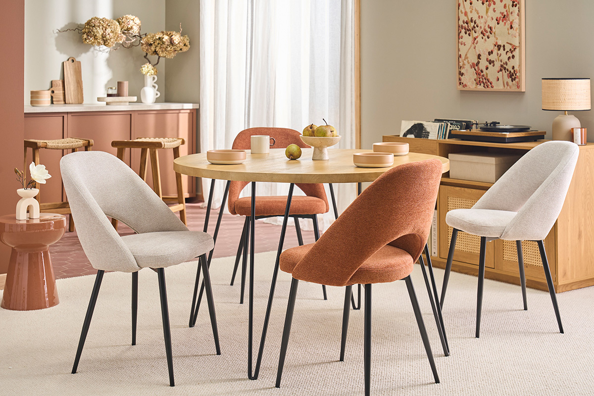 Beige Samt-Effekt Stoffst�hle, schwarze Metallbeine, um einen runden Tisch herum.