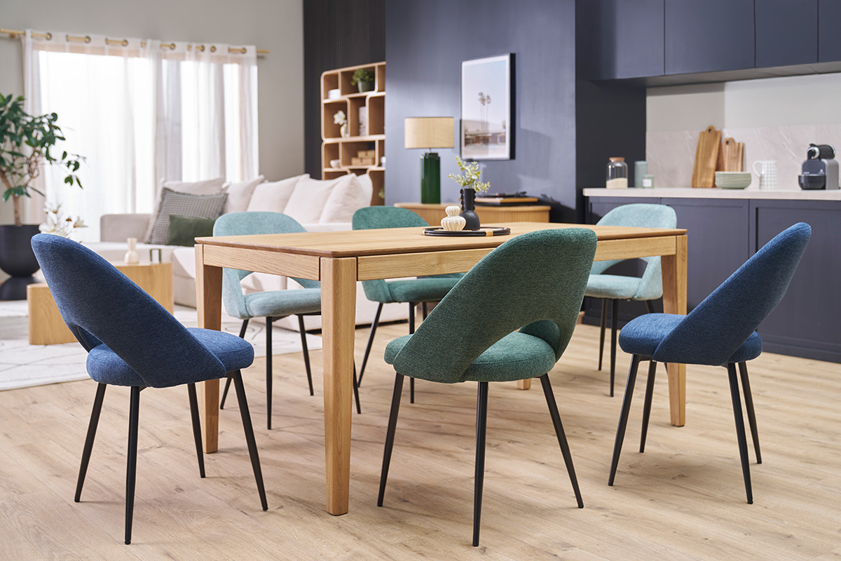Gr�ne und blaue Vintage-St�hle um einen Holztisch in einem modernen Esszimmer.