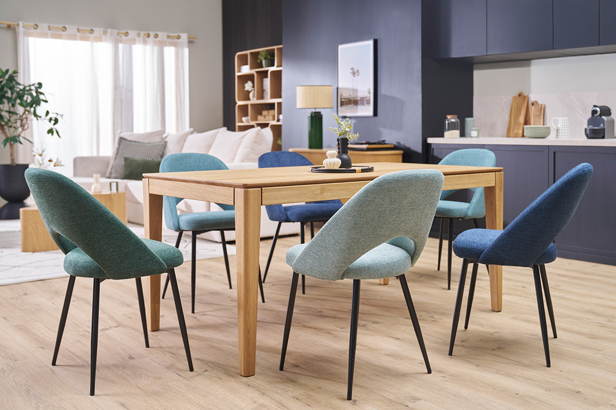 C�ladongr�ne Samtstoffst�hle und schwarze Metallbeine um einen Holztisch, Innenansicht.