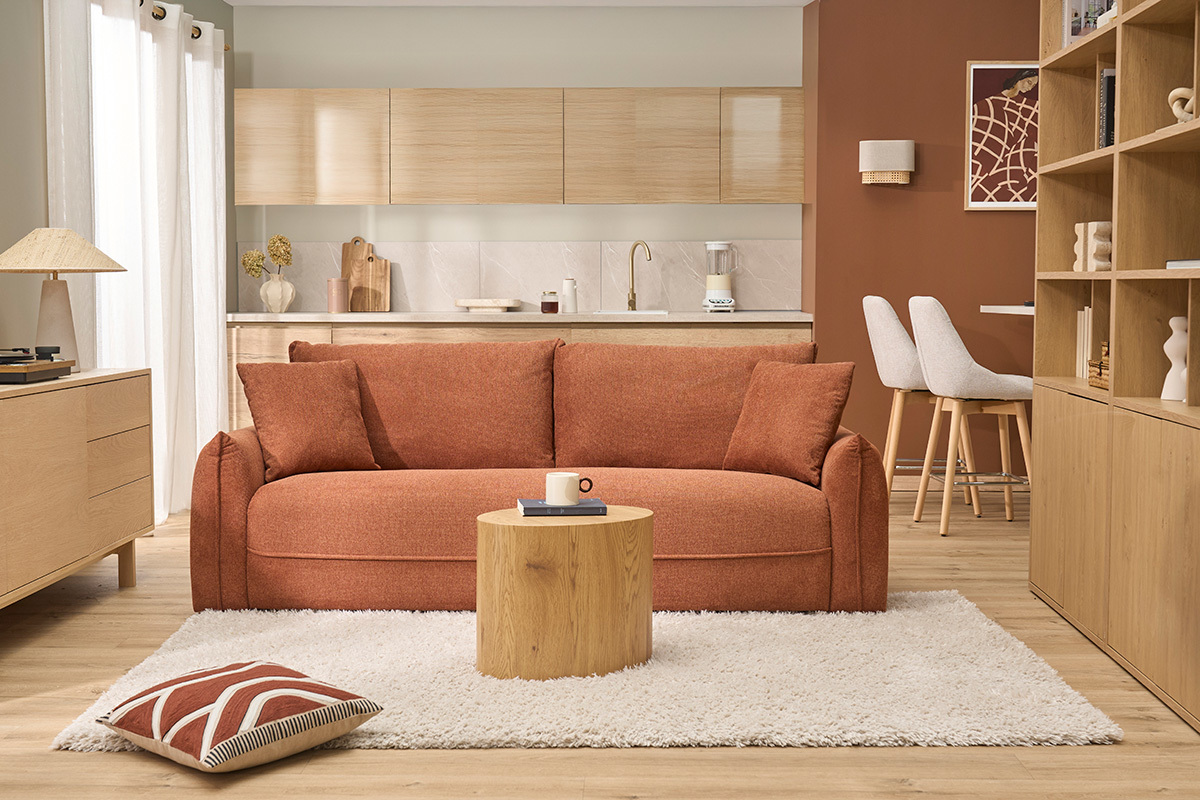 Modernes Wohnzimmer mit Wandlampe aus beigem Leinen und Rattan, orangefarbenem Sofa und Holz-Couchtisch.