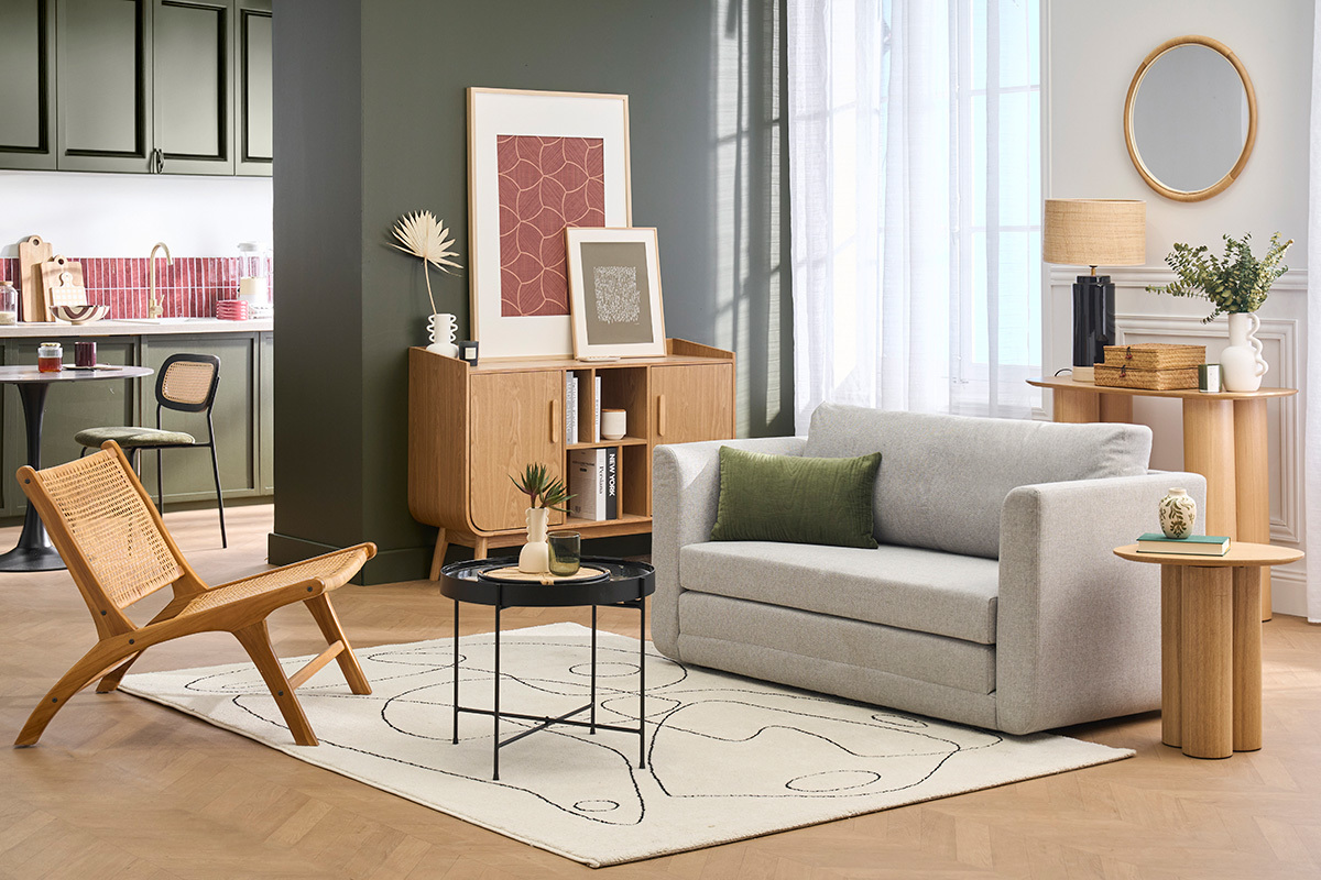 Wohnzimmer mit 2-Sitzer-Schlafsofa in hellem Graustoff, schwarzem Couchtisch und Holzstuhl.